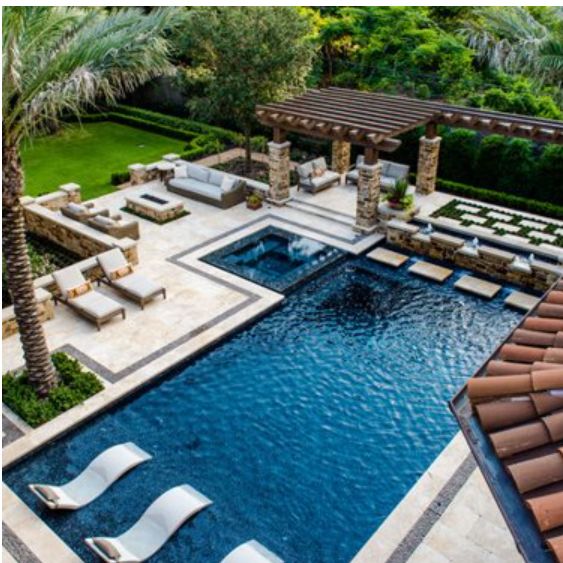 an aerial view of a pool with lounge chairs and palm trees in the foreground