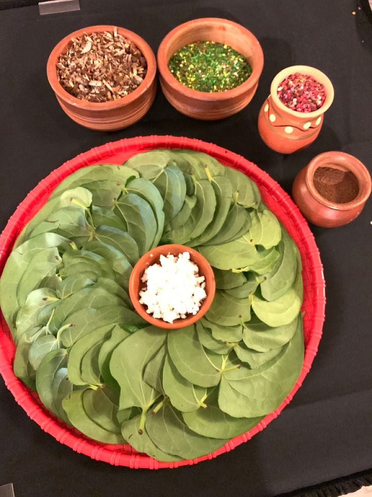 a table topped with bowls filled with plants and spices