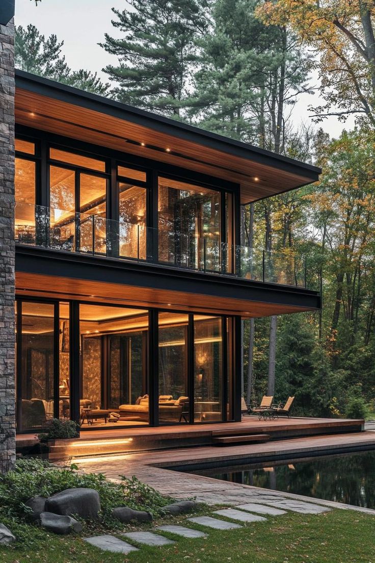 a modern house in the woods with lots of windows