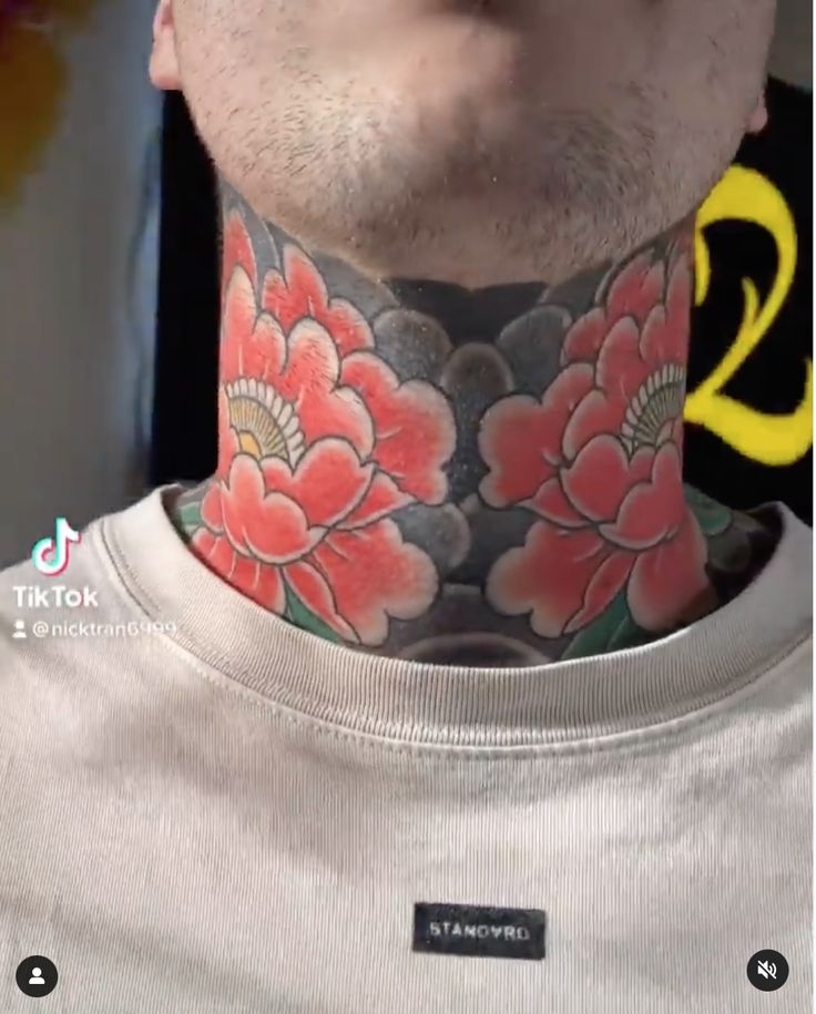 a man with a flower tattoo on his neck