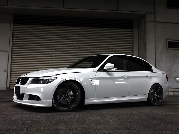 a white car parked in front of a garage door