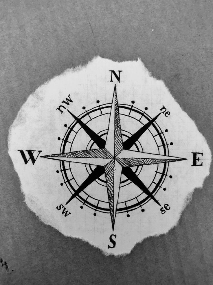 a black and white photo of a compass on the side of a piece of paper