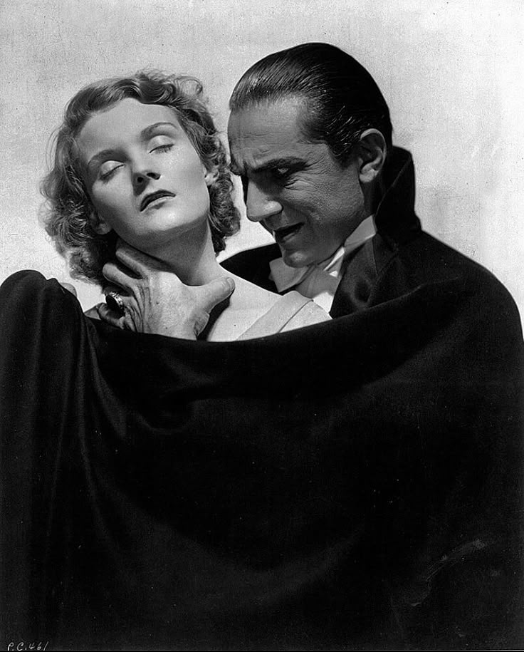 an old black and white photo of two people dressed as dracula and the woman is covering her face with a blanket