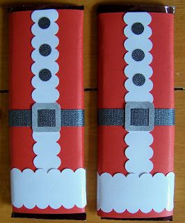 two red and white santa clause christmas crackers on top of a wooden table next to each other