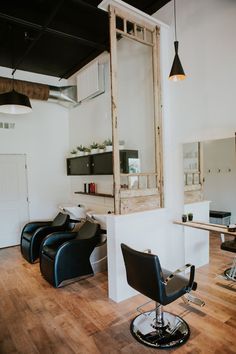 a hair salon with chairs and mirrors in it