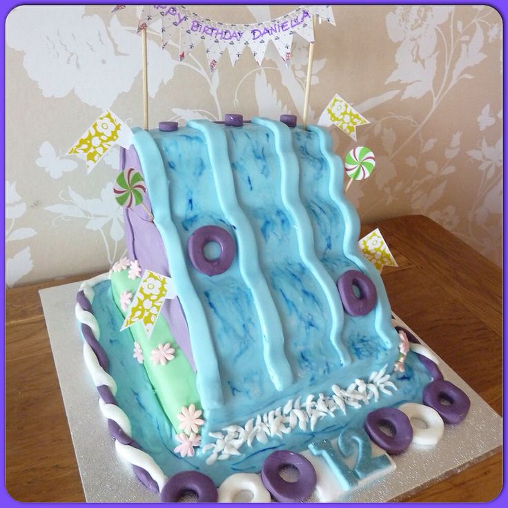 a blue and purple birthday cake sitting on top of a table