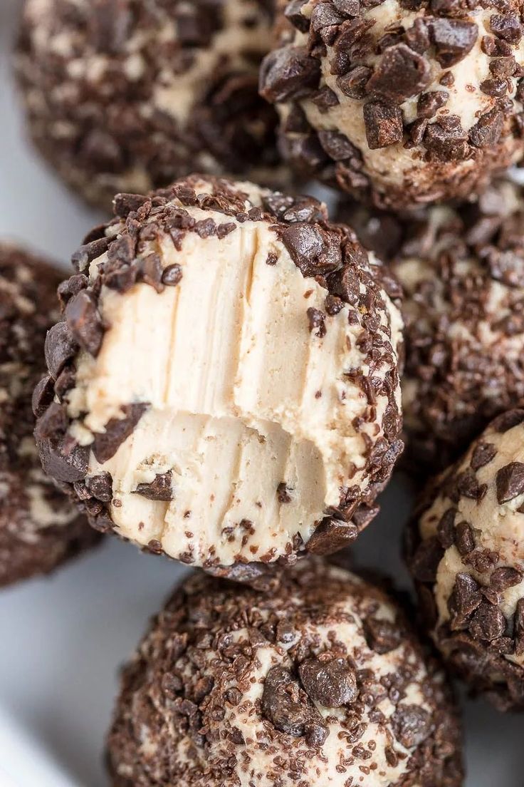 chocolate and peanut butter balls are piled on top of each other in a white bowl