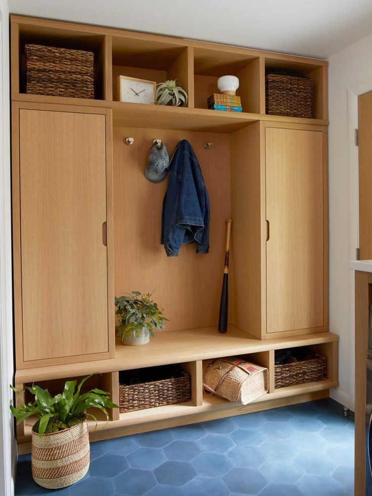 a room with some wooden cabinets and baskets on the wall next to a blue floor