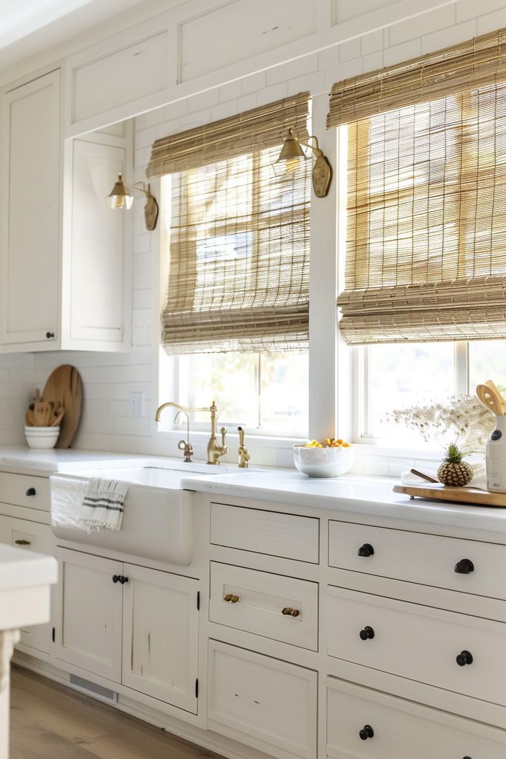 a kitchen with white cabinets and wooden blinds