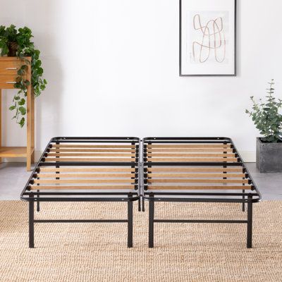 two metal and wood bed frames sitting on top of a rug in a living room