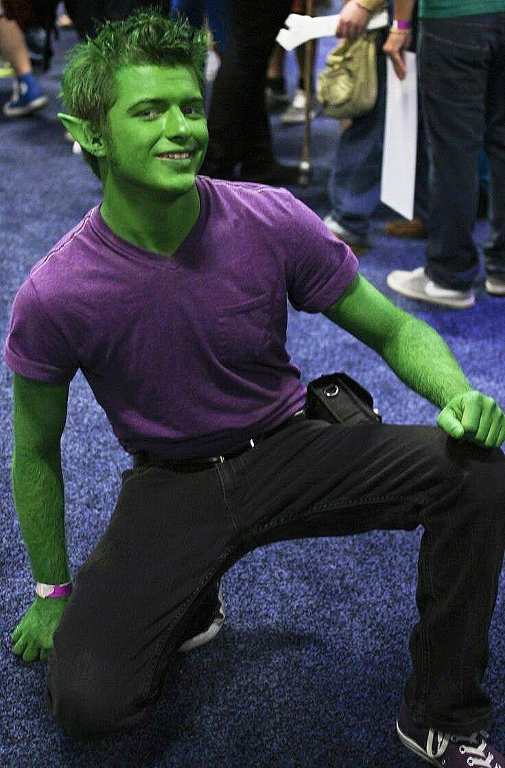 a man dressed as the incredible hulk sits in front of a group of people at an event