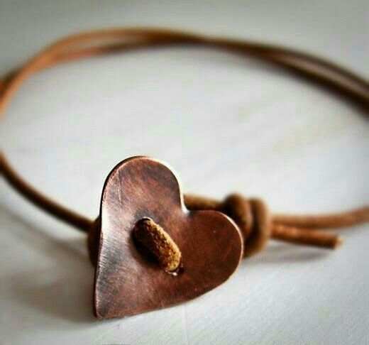 a brown leather bracelet with a heart on it