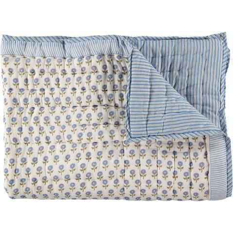 a blue and white flowered comforter on top of a bed with striped sheets