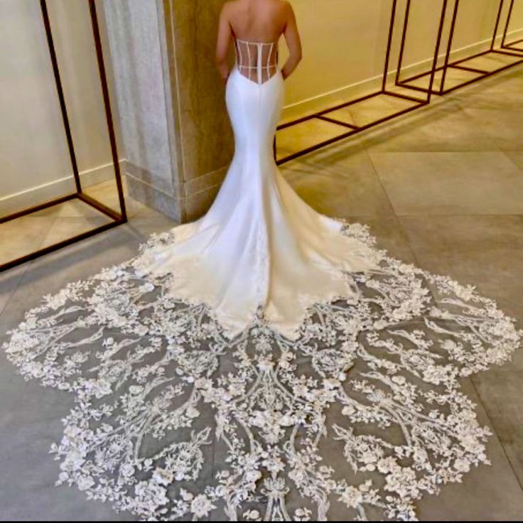 a woman in a wedding dress is standing on the floor with her back to the camera