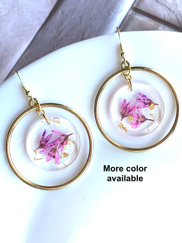 a pair of earrings with pink flowers on them