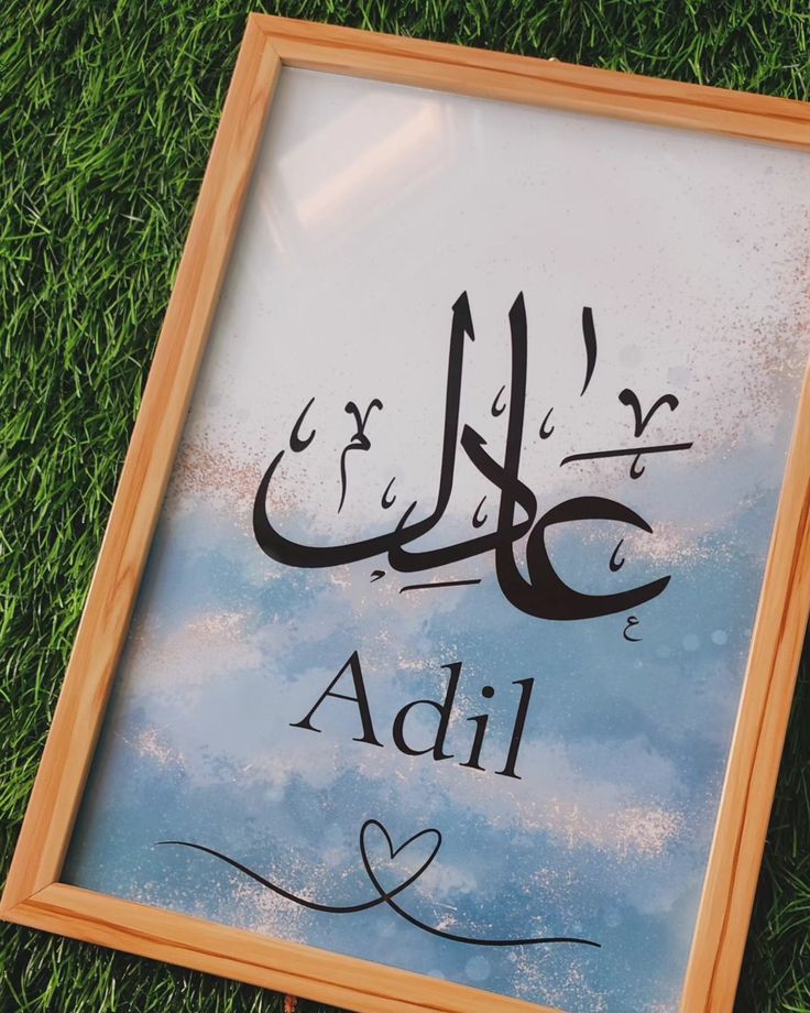 an arabic calligraphy is displayed on the grass in front of a sign that reads, adil