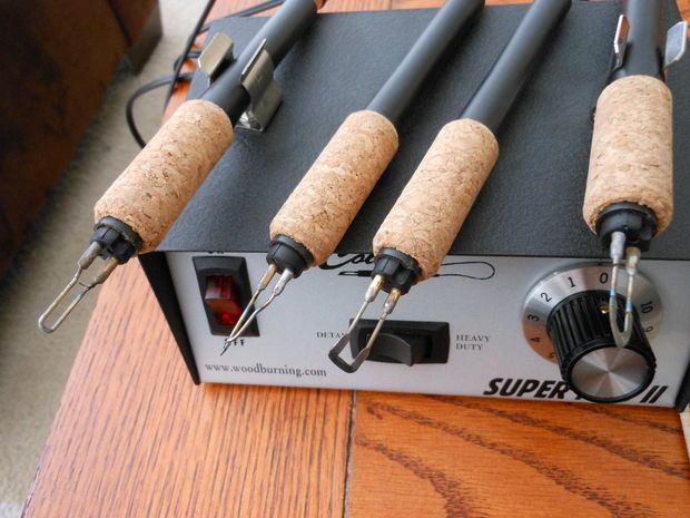 four different types of microphones on top of a wooden table next to each other