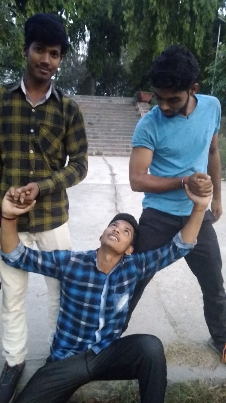 three young men standing around one another