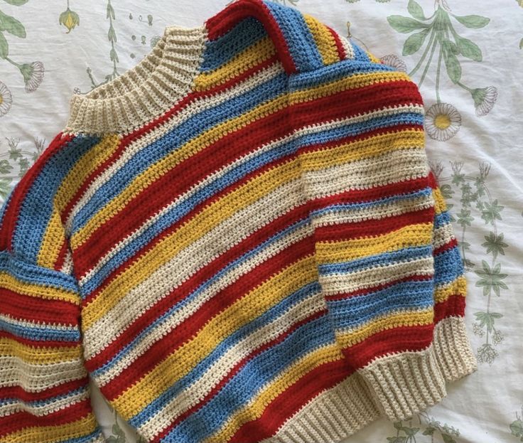 a striped sweater laying on top of a bed