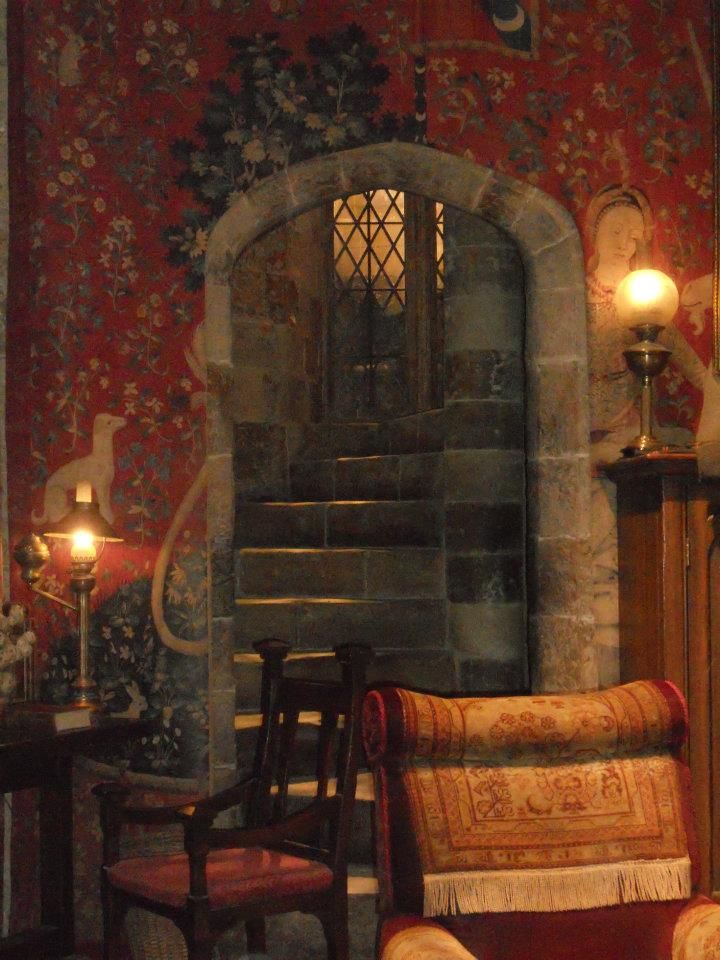 a chair and table in front of a stone wall with an arched doorway on it