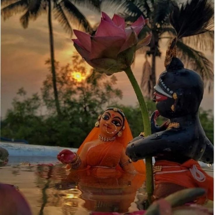 two statues sitting next to each other in the water