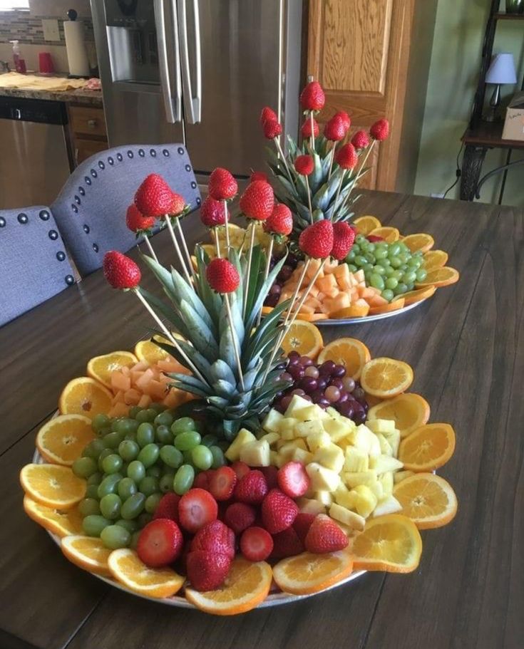 two plates filled with fruit on top of a wooden table