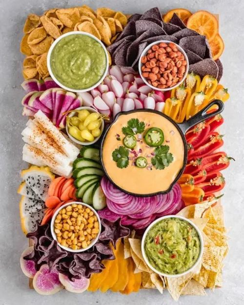 a platter filled with different types of food and condiments, including guacamole