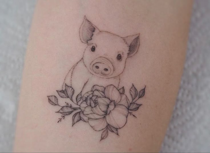 a small pig with flowers around it's neck is on the leg and has an arrow in its ear