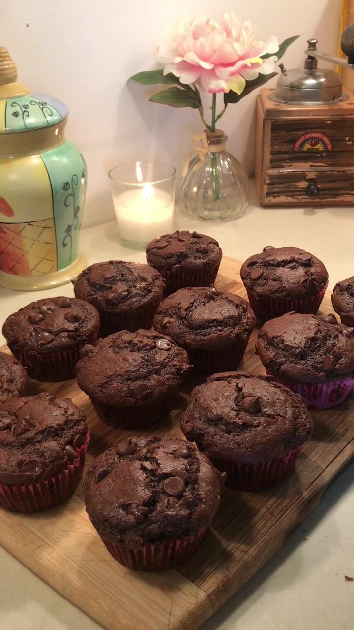 chocolate muffins on a cutting board next to a candle