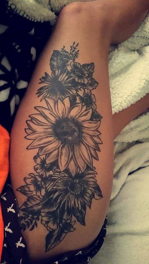 a woman's thigh with sunflowers and butterflies on it