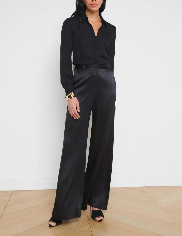 L'Agence Pilar Wide Leg Pant in black. Core L'Agence items are not stocked items and are placed by Steven Dann as we receive your order. Please allow 7-15 business days for this to ship. Not available for expedited shipping. High waisted. Wide leg. Flared hem. Belt loops. Side pockets. Back welt pockets. Front zip fly closure. Hidden hook and bar closure. This item runs long. Tailoring at the hem may be needed. 100% Silk. Rise: 11". Inseam: 34". Leg Opening: 14.4". Model Details: 5’10”| Bust: 34" | Waist: 23" | Hips: 34.5" | Wearing a Size 2. Imported. Dry clean. Black Silk Trousers Outfit, Black Silk Pants Outfit, Black Satin Pants Outfit, Silk Pants Outfit, Black Satin Pants, Silk Wide Leg Pants, Silk Pant, Elegant Pant, Dark Christmas