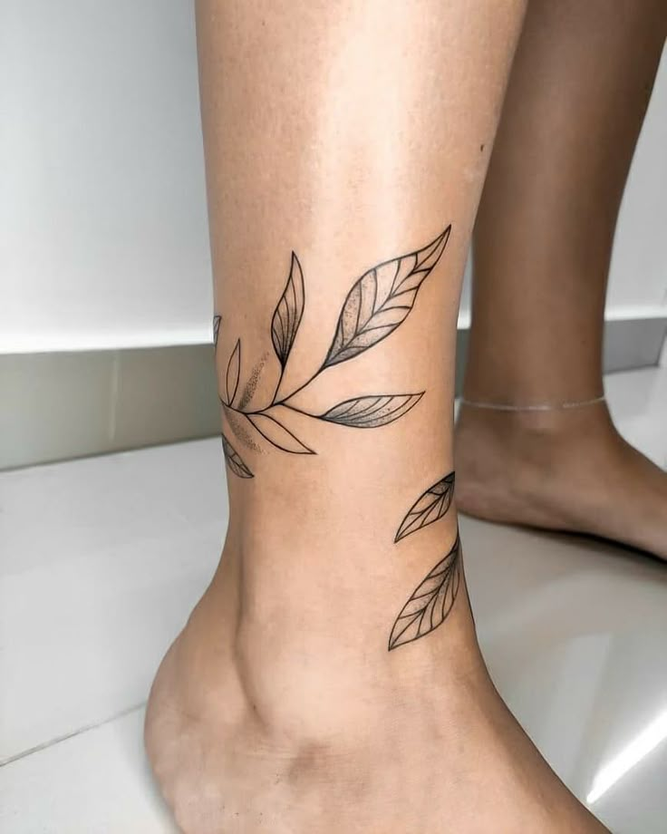 a woman's foot with a leaf tattoo on her left ankle and the bottom part of her leg