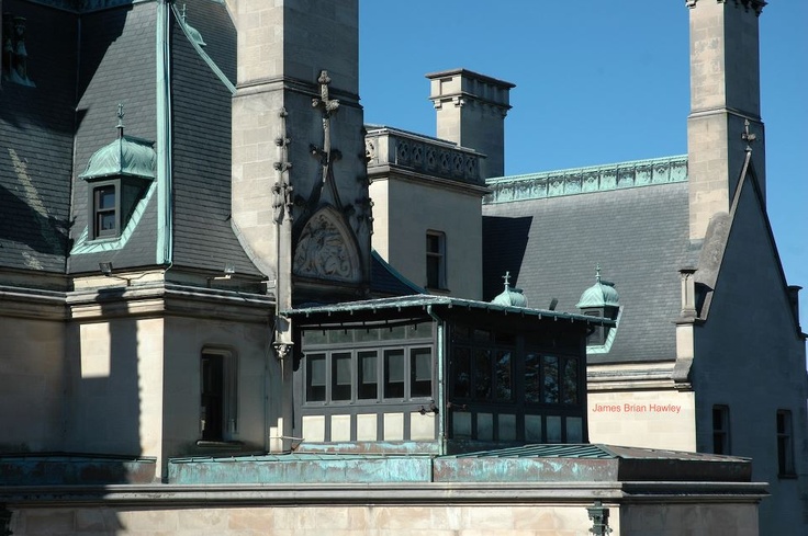 an old building with two towers and a clock on it's front porch,