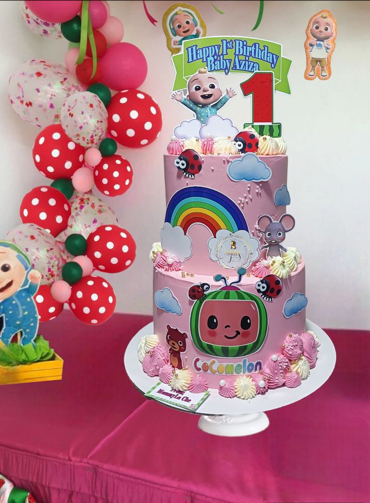 a pink birthday cake sitting on top of a table