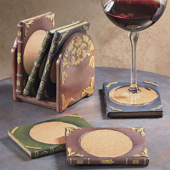 a glass of wine sitting on top of a table next to coasters and books