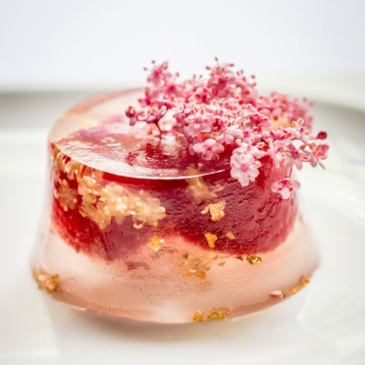 a cake with pink and gold sprinkles on it sitting on a white plate