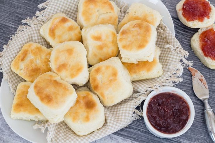 some biscuits are sitting on a plate with jam