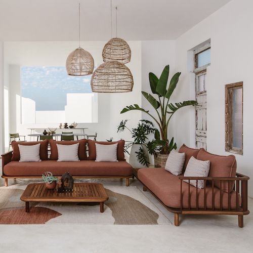 a living room filled with lots of furniture next to a large potted palm tree