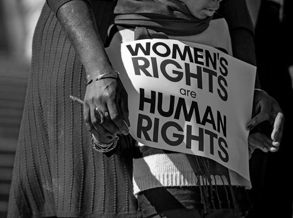 a woman holding a sign that says women's rights are human rights