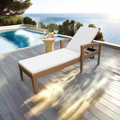 a lounge chair sitting on top of a wooden deck next to a swimming pool