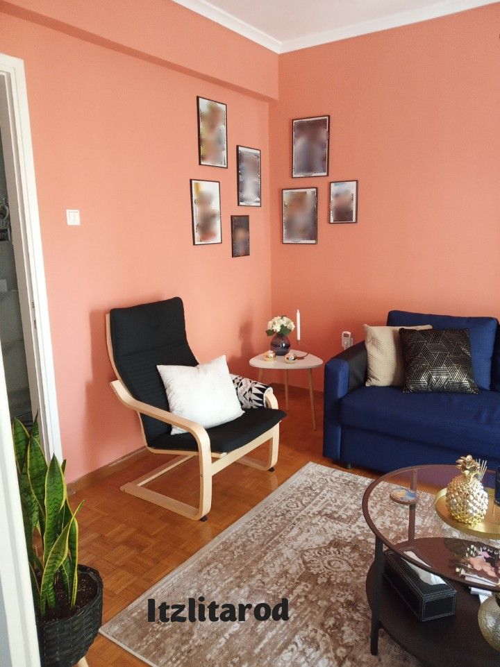 a living room with pink walls and blue furniture