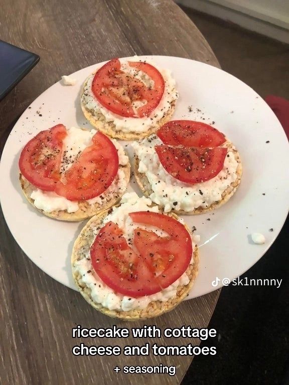 four small sandwiches with tomatoes and cheese on a white plate