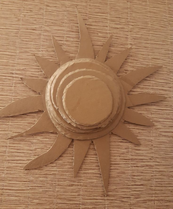 three pieces of cardboard sitting on top of a bamboo mat with the shape of a sun