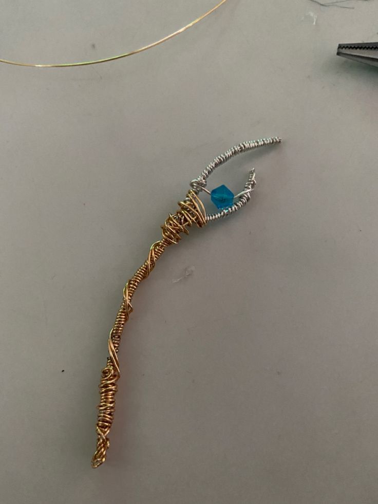 a piece of jewelry sitting on top of a table next to a pair of scissors