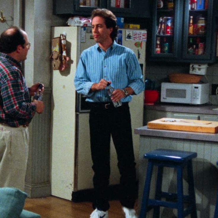 two men standing in a kitchen talking to each other