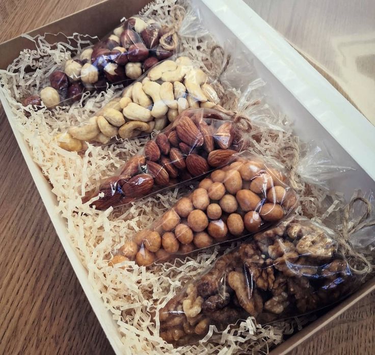 an open box filled with assorted nuts on top of a wooden table