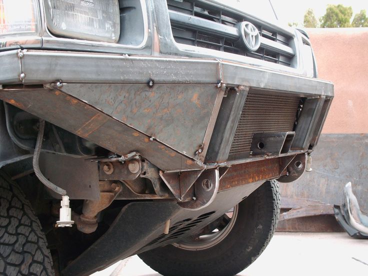 the front end of a vehicle that has been rusted and is parked on concrete