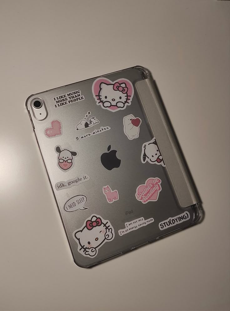 an ipad case with hello kitty stickers on the back and sides, sitting on a table