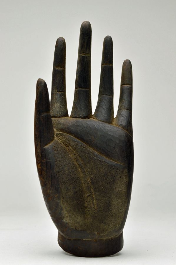 a wooden hand sculpture sitting on top of a white table