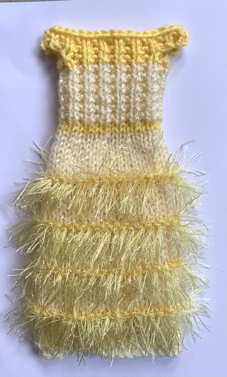 a yellow and white knitted dress with fringes